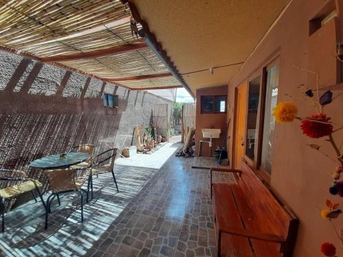 a house with a patio with a table and chairs at Casa Sutar Los Pimientos in San Pedro de Atacama
