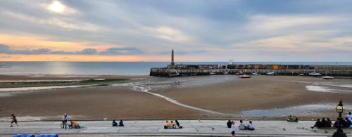 a group of people walking on a beach near the ocean at Imperial Suites Heart Of Margate! sleeps 6 in Kent