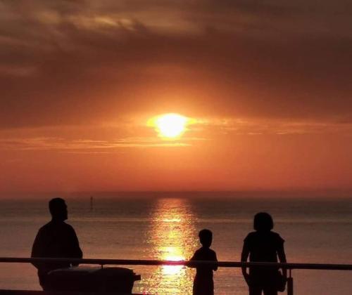 a group of people watching the sunset on the beach at Imperial Suites Heart Of Margate! sleeps 6 in Kent