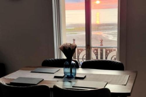 a table with a vase of flowers on top of a window at Imperial Suites Heart Of Margate! sleeps 6 in Kent