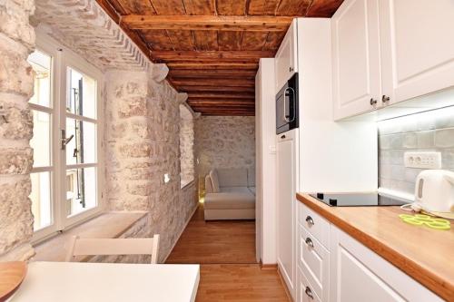 a kitchen with white cabinets and a counter top at Pearl in the Heart of Old Town on Belavista Square in Herceg Novi in Herceg-Novi