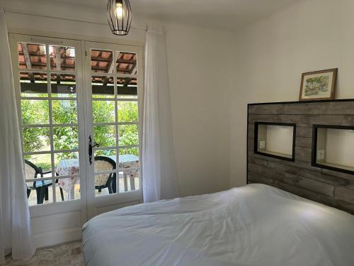 une chambre avec un lit et une grande fenêtre dans l'établissement Villa entière au calme dans village provençal, à Peymeinade