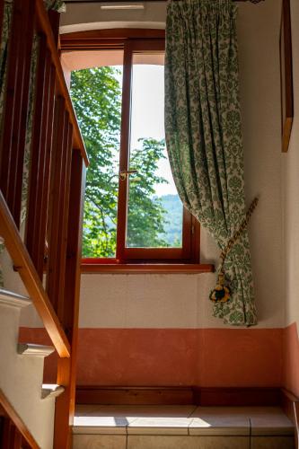 a room with a window and a staircase with a curtain at Nogherazza - La Locanda in Belluno
