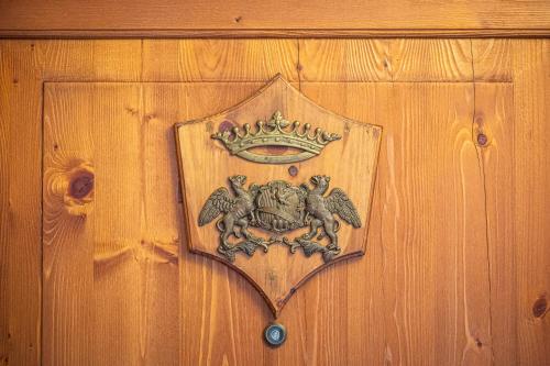 a crest on a wooden door with a crown on it at Nogherazza - La Locanda in Belluno