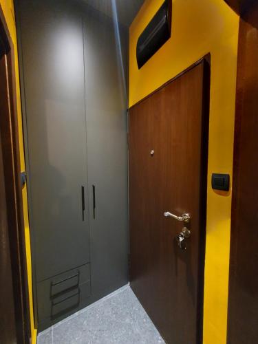 a bathroom with a metal door and a wooden wall at Studio apartman Luka in Cetinje