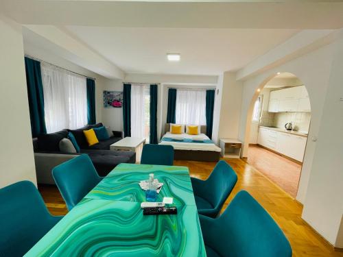 uma sala de estar com uma mesa e cadeiras azuis em Front Beach Exclusive Apartments em Struga