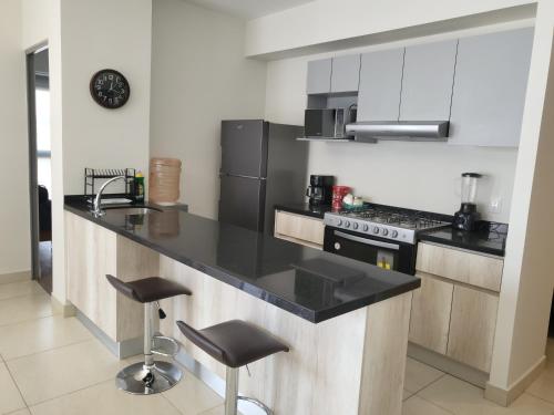 a kitchen with a black counter top in a room at Departamento familiar o de negocios in Guadalajara