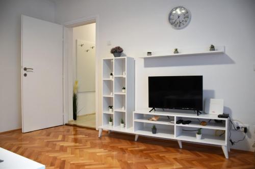 a living room with a white entertainment center with a flat screen tv at Apartman DJURDJEVAK in Vršac