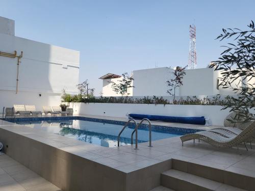 a swimming pool with chairs next to a building at Departamento familiar o de negocios in Guadalajara