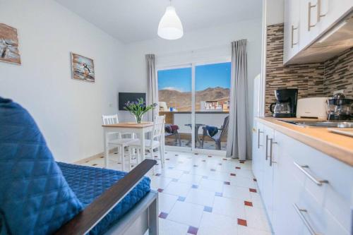 a kitchen with a counter and a table with a view at Tindaya in Las Playas