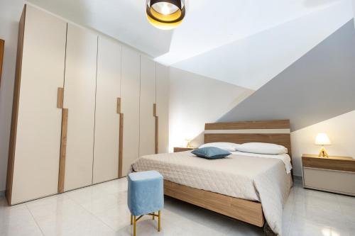 a bedroom with a bed and a blue chair at Casa vacanza lido in Sciacca