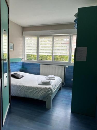 a hospital room with a bed and two windows at Hôte de la Plage in Dunkerque