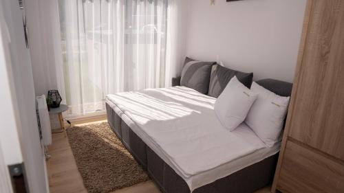 een bed in een kamer met een raam bij Baltic Sea Flair: Just steps from the sea in Dziwnów