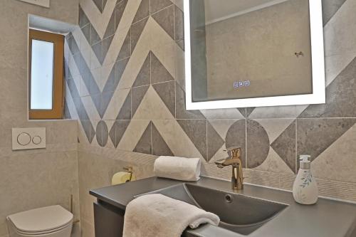 ein Badezimmer mit einem Waschbecken, einem WC und einem Spiegel in der Unterkunft Apartment SB77 Leogang in Leogang