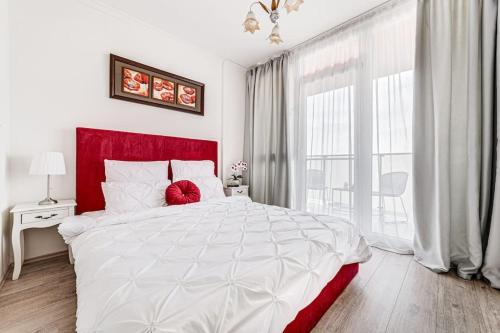 ein weißes Bett mit einem roten Kopfteil in einem Schlafzimmer in der Unterkunft Dodi RED Apartament in Arad
