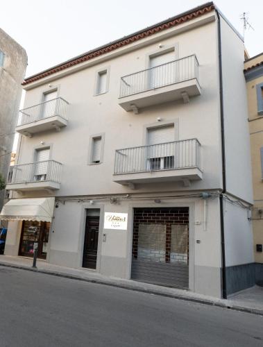 a white building with two balconies on a street at Umberto I Nicosia in Nicosia