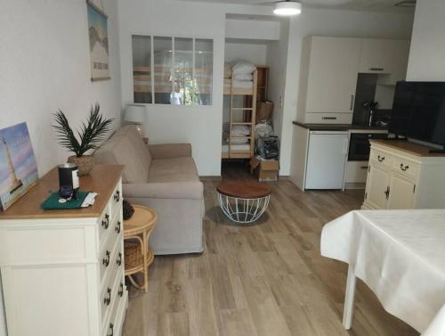 ein Wohnzimmer mit einem Sofa und einer Küche in der Unterkunft Au charme de St Georges in Saint-Georges-de-Didonne