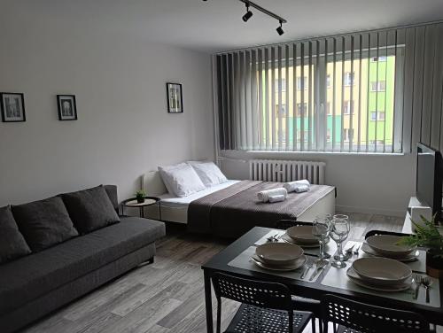 Sala de estar con cama y mesa en Apartamenty Oświęcim klimatyzacja air-conditioned, en Oświęcim