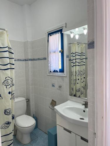a bathroom with a toilet and a sink and a mirror at ΞΕΝΟΔΟΧΕΙΟ ΑΚΡΩΤΗΡΙ in Platia Ammos