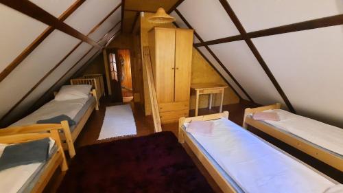 a room with four beds in a attic at Między Sosnami in Jedwabno