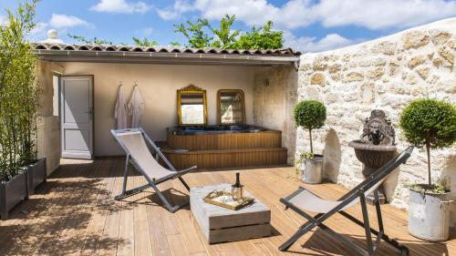 un patio con 2 sillas y una mesa en Clos Marcamps - Teritoria, en Prignac-et-Marcamps
