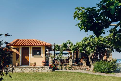 a small yellow house with a tile roof at Villa Yianna in Néa Meságkala
