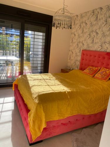 1 dormitorio con 1 cama grande con manta amarilla y roja en Apartment with terrace in Flamenco village urbanization, en Orihuela