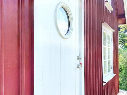 a red house with a white door and a window at Holiday home BLEKET II in Bleket