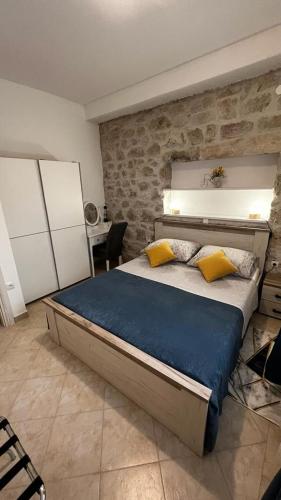 um quarto com uma cama grande e almofadas amarelas em Grošovi Dvori em Opuzen