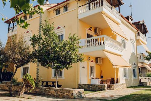 a large yellow building with a balcony at Villa Yianna in Néa Meságkala