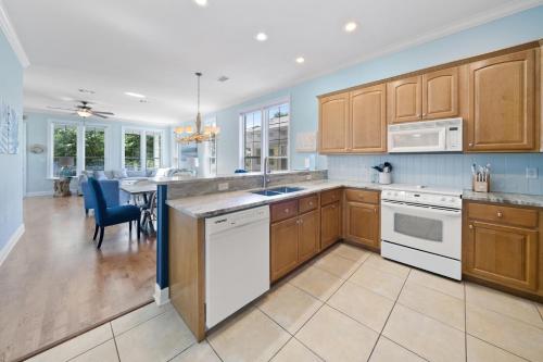 a kitchen with wooden cabinets and a dining room at 30A Rise and Shine in Seagrove Beach