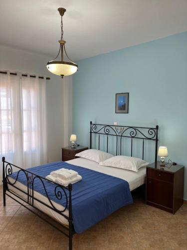 1 dormitorio con 1 cama con sábanas azules y manta azul en ΞΕΝΟΔΟΧΕΙΟ ΑΚΡΩΤΗΡΙ en Platia Ammos