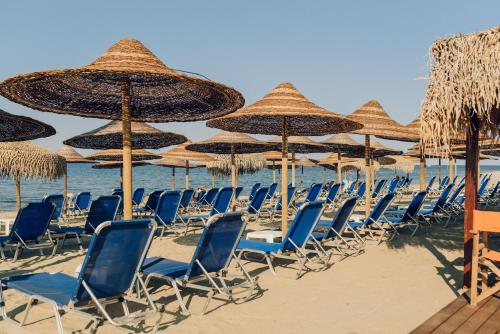 a group of chairs and umbrellas on a beach at Villa Yianna in Néa Meságkala