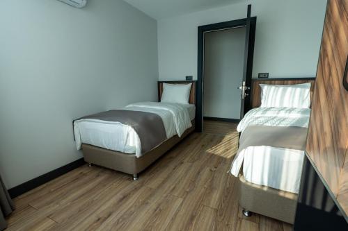 two beds in a room with wooden floors at Yusufhan Suites in Trabzon