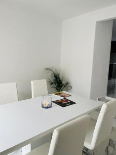 a white table with white chairs and a candle on it at Dear John in Hydra