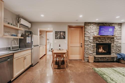 eine Küche mit Tisch und Steinkamin in der Unterkunft 08MBR - Starlink - Gas F P - BBQ - Sleeps 2 home in Glacier