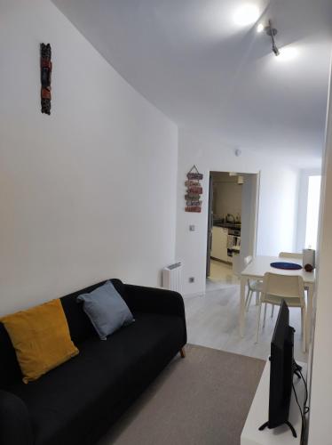 a living room with a black couch and a table at Vista Panorâmica Amadora in Amadora