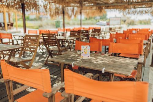a group of tables and chairs with orange chairs at Villa Yianna in Néa Meságkala
