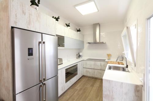 a kitchen with a stainless steel refrigerator and a sink at Sitges Centre Mediterranean House- 5 Bedroom, 4 Bathroom, Terrace Courtyard, Private Rooptop Pool in Sitges