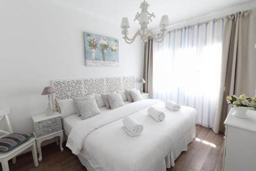 a white bedroom with a large white bed with white pillows at Sitges Centre Mediterranean House- 5 Bedroom, 4 Bathroom, Terrace Courtyard, Private Rooptop Pool in Sitges