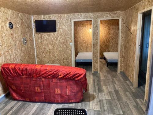 een woonkamer met een rode bank en een tv bij Chalet climatisé n°2 in Verrières