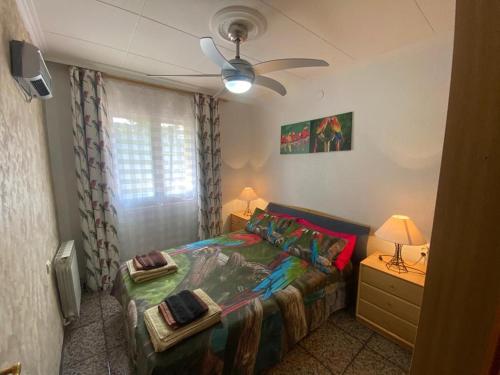 1 dormitorio con 1 cama y ventilador de techo en Villa Porta Caeli, en Tarragona