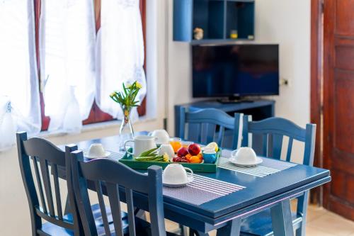 una mesa azul con una bandeja de fruta. en Le Terrazze di Apollo - Case Tilotta en Marinella di Selinunte