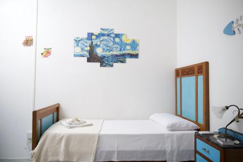 una camera da letto con un letto e un dipinto sul muro di Appartamento Casa Tonina a Carloforte