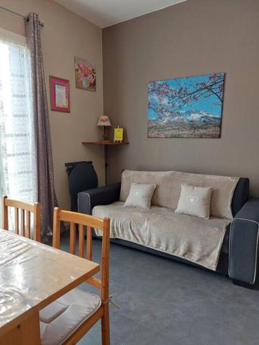 un salon avec un canapé et une table dans l'établissement Studio à la montagne en rez-de-jardin, à Montclar