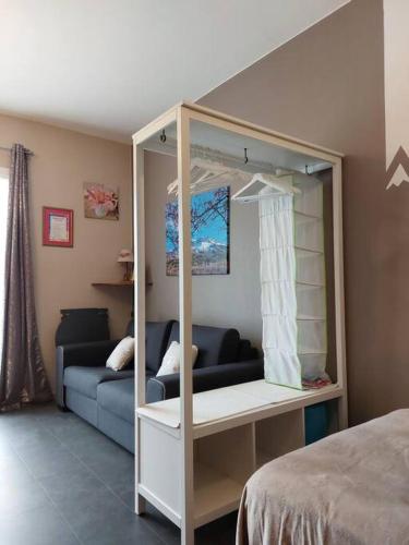 une chambre avec un lit à baldaquin et un canapé dans l'établissement Studio à la montagne en rez-de-jardin, à Montclar