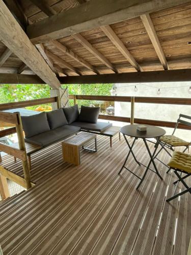 - une terrasse couverte avec un canapé, une table et des chaises dans l'établissement B&B Cozy Emotions, à La Baume-dʼHostun