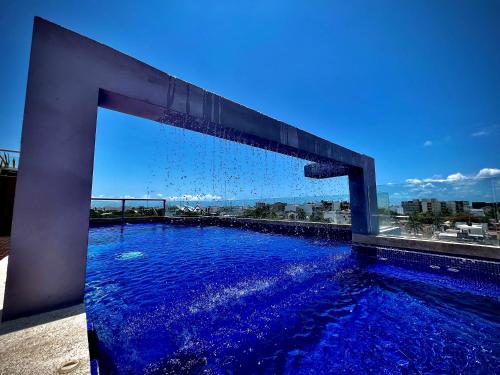 a swimming pool with blue water on a building at Playa Centro Rooftop Apartments & Studios in Playa del Carmen