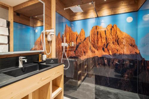 un bagno con un murale di montagna sul muro di Hotel Villa Alpina ***S a Cortina dʼAmpezzo