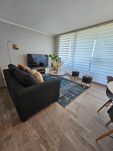 sala de estar con sofá y TV en Hermoso departamento de 2 dormitorios con una vista maravillosa, en Valparaíso